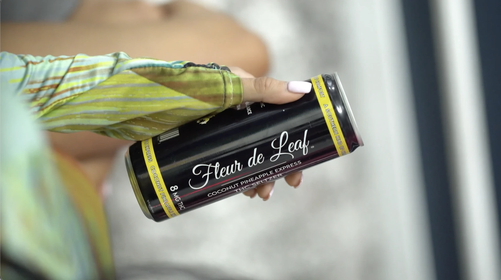 Best THC Seltzer: Why It's Fleur de Leaf 1 A manicured hand holding a can of Fleur de Leaf THC seltzer.